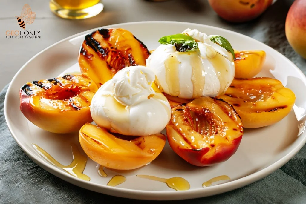 A plate of grilled nectarines topped with creamy burrata cheese and drizzled with honey.